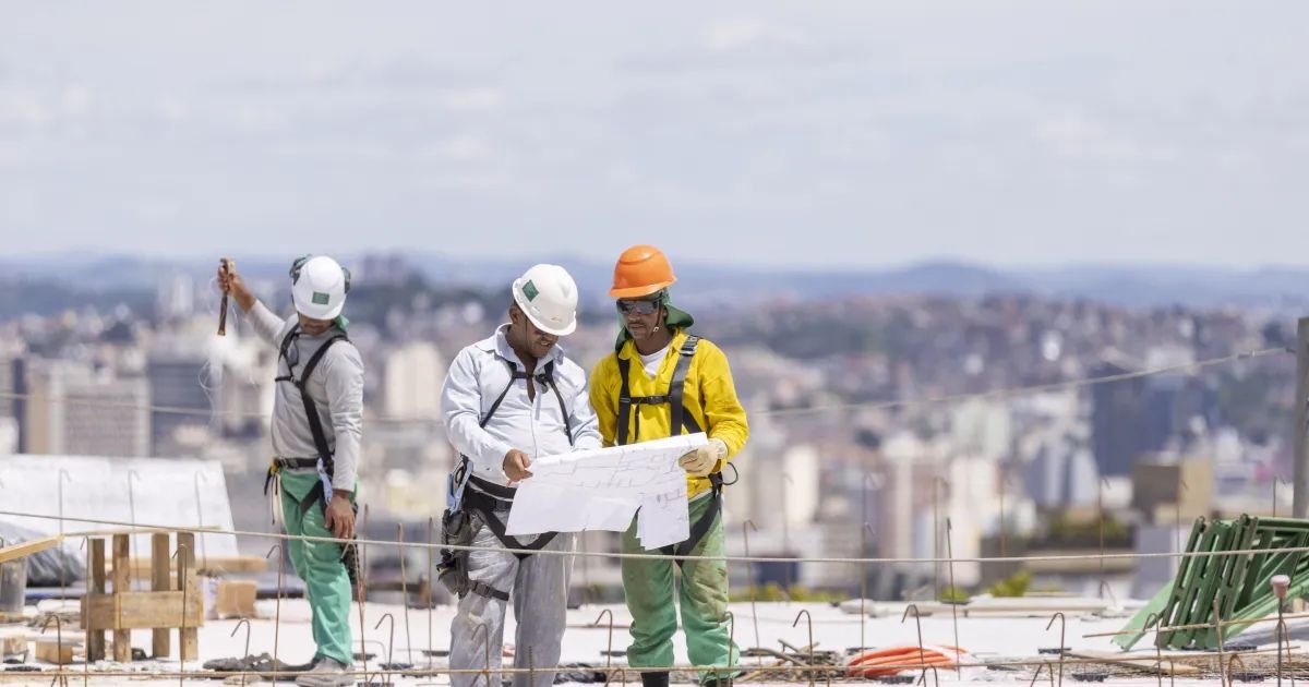Andamento de obra residencial com andaimes e guindaste