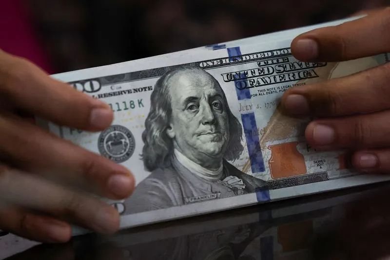 Usuário consultando cotação do dólar em aplicativo bancário antes de viagem
